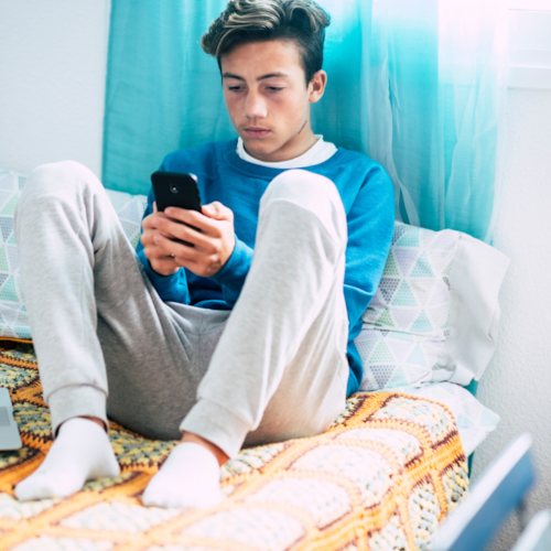 Boy on bed texting